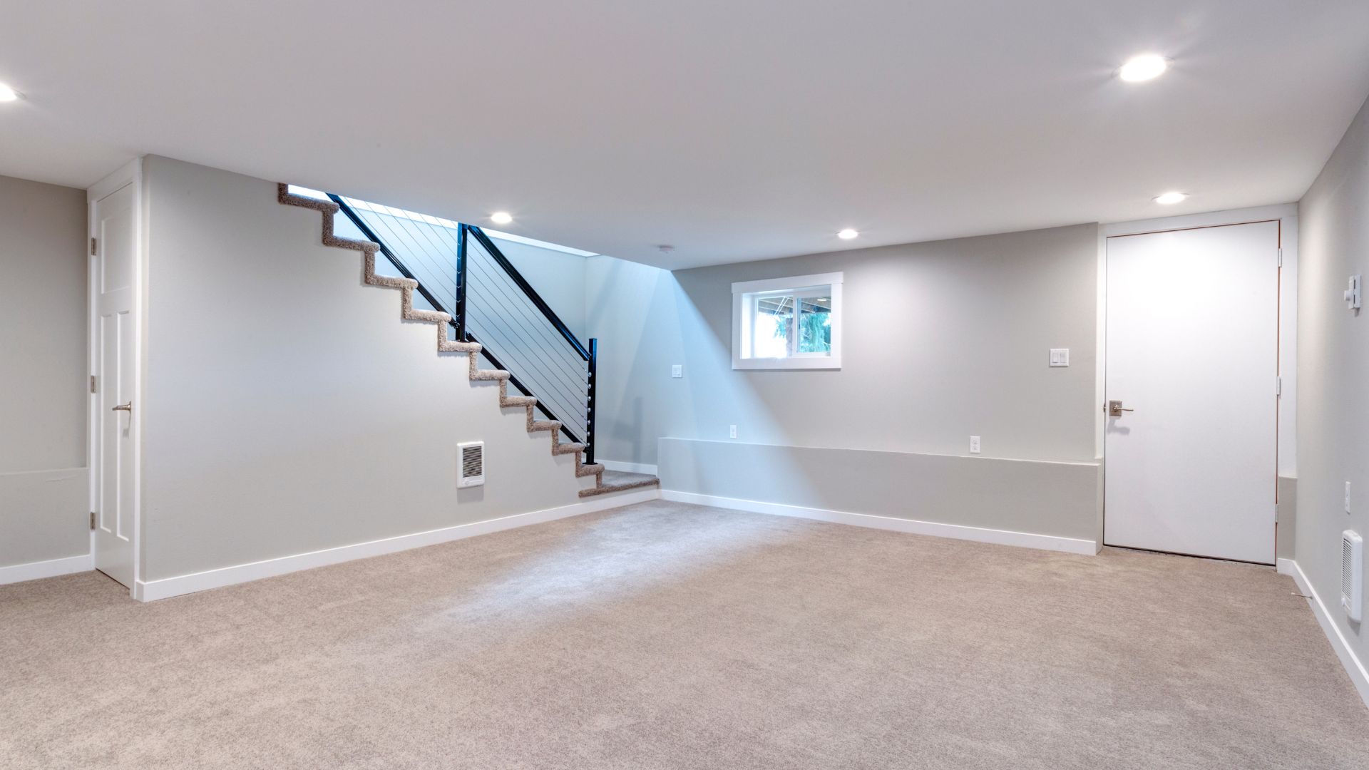 An empty room with a stair case and a window